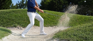 Imagen de ejemplo de un golfista realizando un golpe desde el búnker, momentos después de que el palo golpee la bola