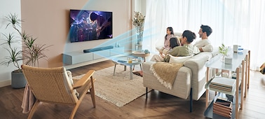 Una familia viendo el televisor con ondas sonoras azules que emanan de la barra de sonido